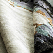 Handmade bamboo silk rug with abstract layered gold, green, and grey tones on a contemporary design.