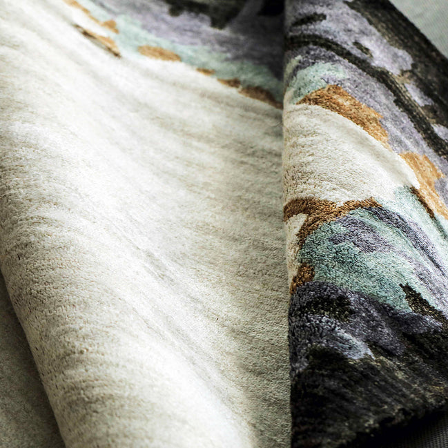 Handmade bamboo silk rug with abstract layered gold, green, and grey tones on a contemporary design.
