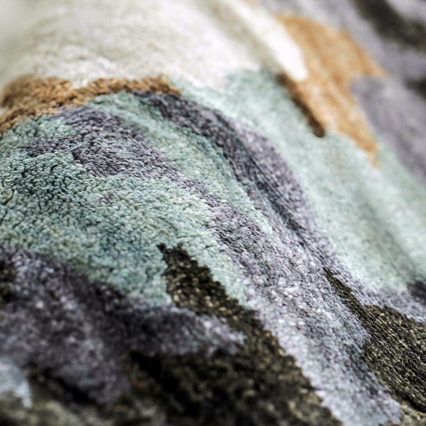 Handmade bamboo silk rug with abstract layered gold, green, and grey tones on a contemporary design.