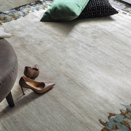 Handmade bamboo silk rug with abstract layered gold, green, and grey tones on a contemporary design.