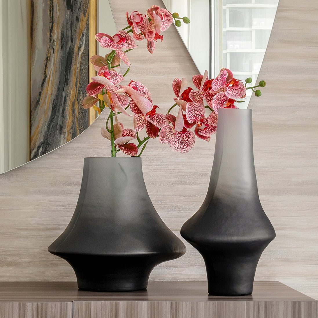 Decorative glass vase with a grey ombre finish and sculptural organic silhouette for contemporary and luxury interiors.
