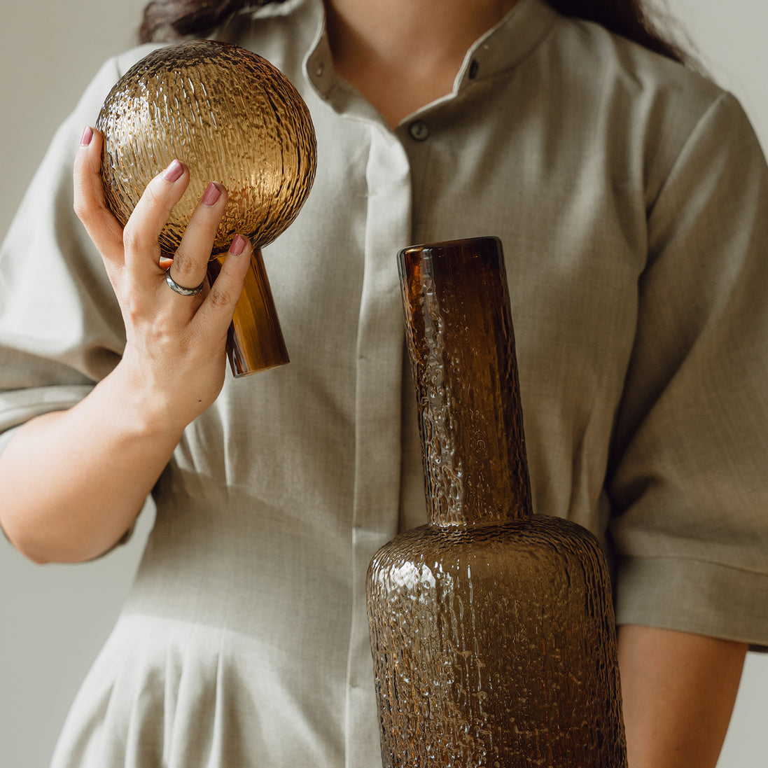 Hand-blown amber glass bottle with an ice-textured finish and rounded stopper for mid-century and contemporary luxury interiors.