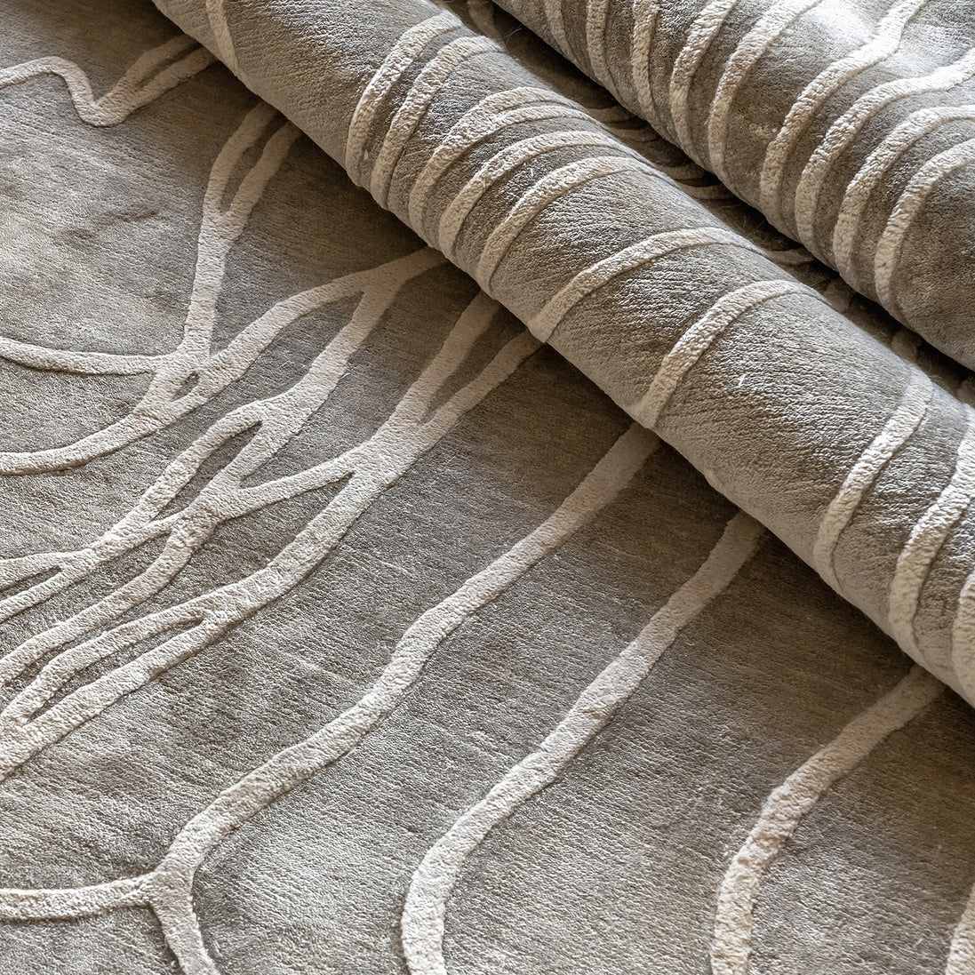 Handmade textured rug with sculpted high-pile waves in an organic pattern for contemporary and luxury interiors.