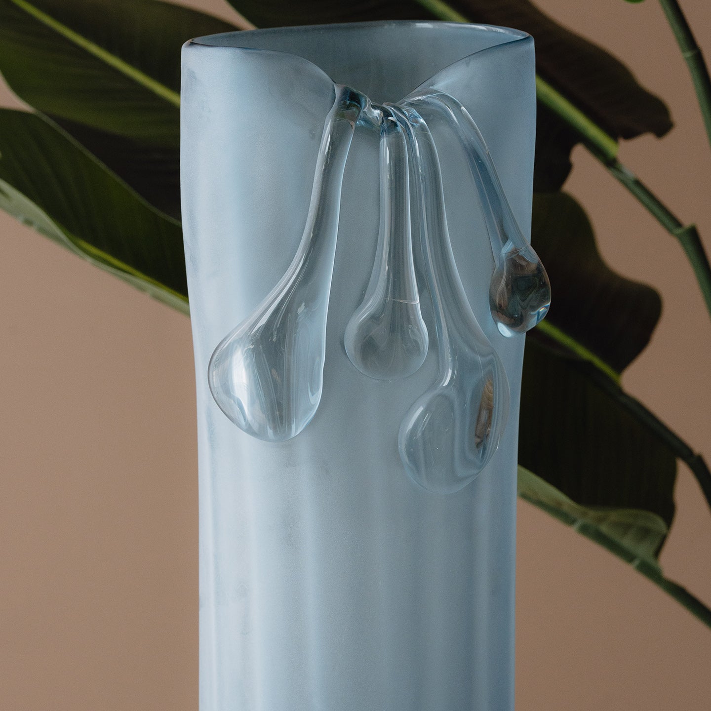 Frosted light blue decorative glass vase with a sculptural flowing silhouette for contemporary and luxury interiors.