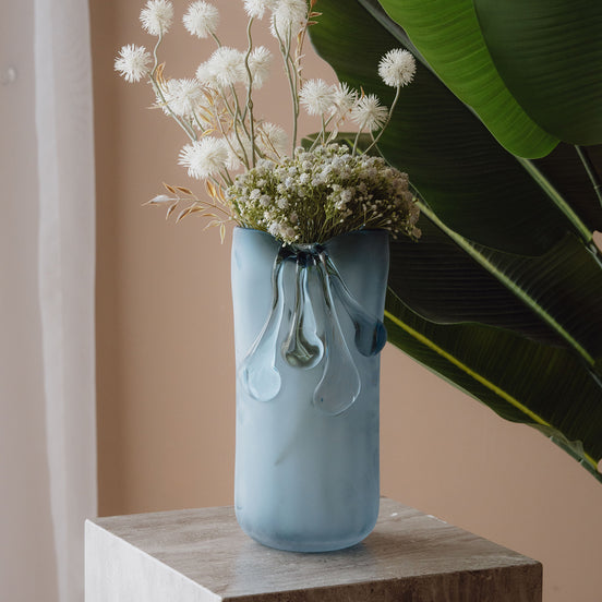 Frosted light blue decorative glass vase with a sculptural flowing silhouette for contemporary and luxury interiors.
