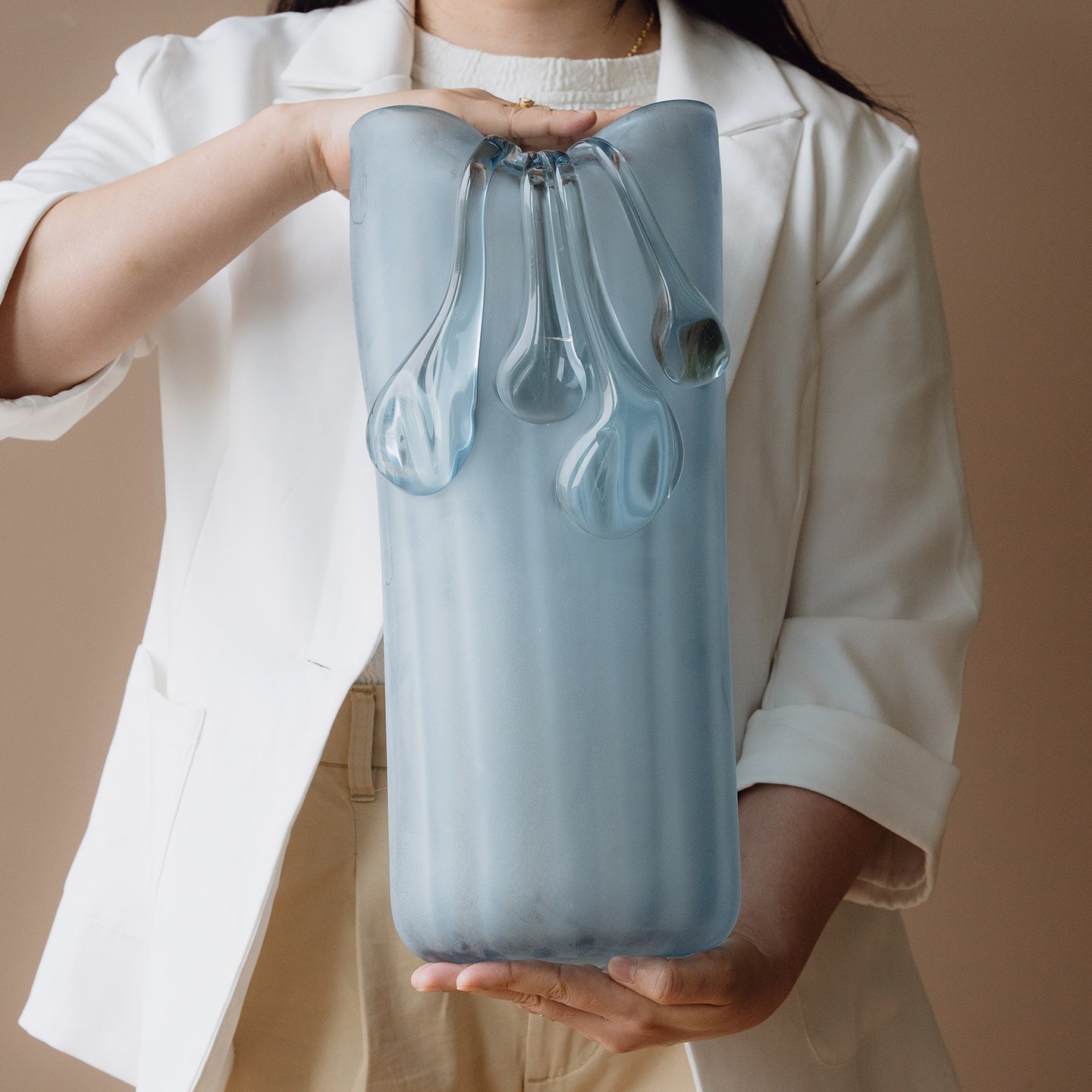 Frosted light blue decorative glass vase with a sculptural flowing silhouette for contemporary and luxury interiors.