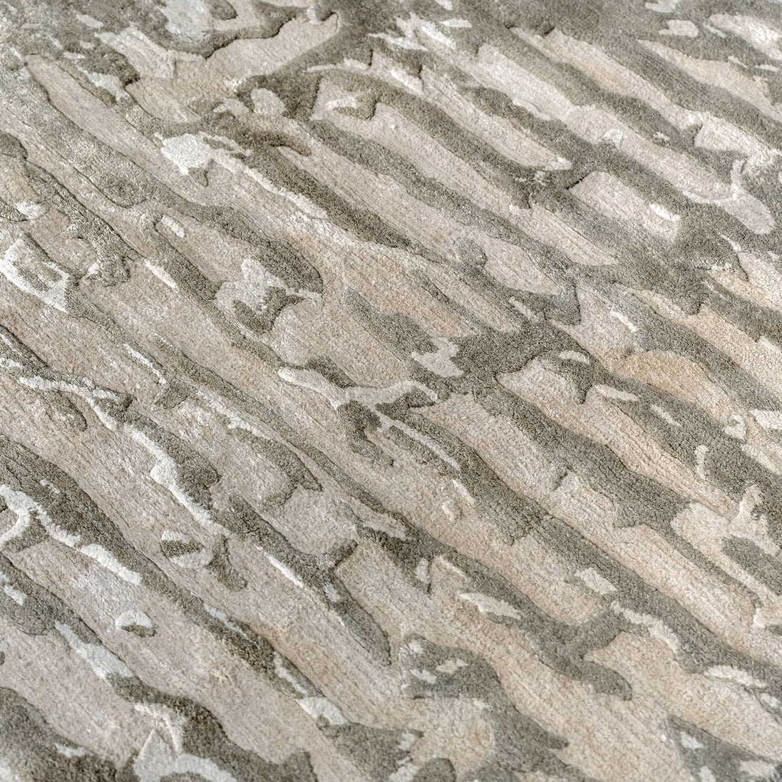 Handmade bamboo silk rug with an abstract design in warm beige and cream tones for contemporary and luxury interiors.