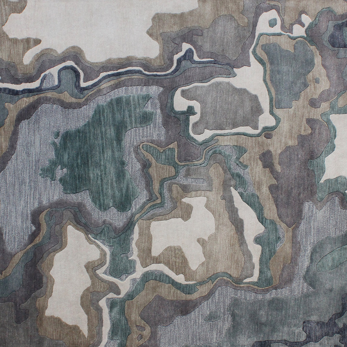 Handmade bamboo silk rug with textured organic motifs in soft blue, deep green, and neutral tones inspired by flowing water.