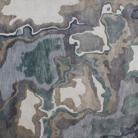 Handmade bamboo silk rug with textured organic motifs in soft blue, deep green, and neutral tones inspired by flowing water.