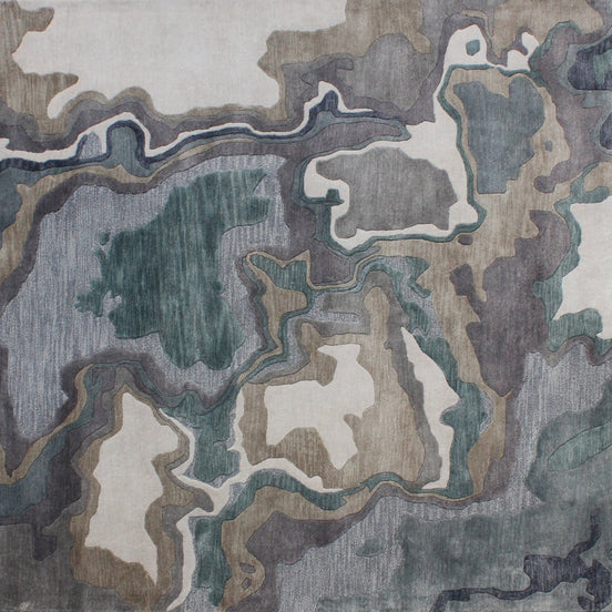 Handmade bamboo silk rug with textured organic motifs in soft blue, deep green, and neutral tones inspired by flowing water.