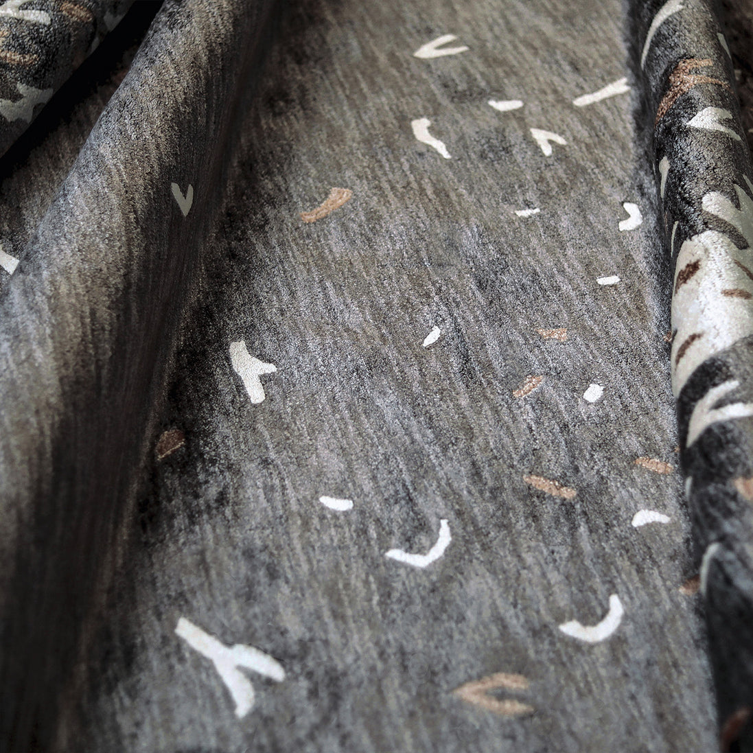 Handmade botanical rug inspired by UAE palm leaves with delicate leaf motifs fading into soft scattered flecks of colour.
