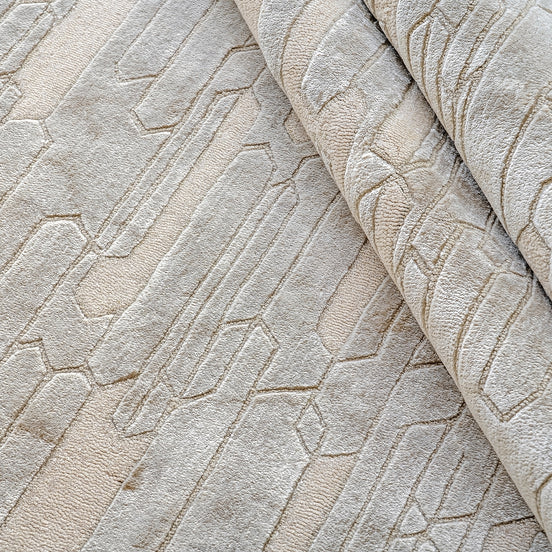 Handmade geometric rug with a textured monotone design and varying pile heights for contemporary luxury interiors.