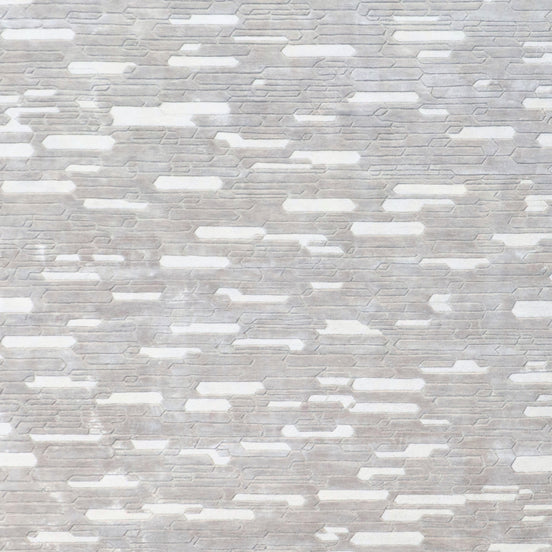Handmade geometric rug with a textured monotone design and varying pile heights for contemporary luxury interiors.