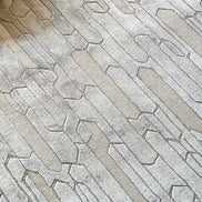 Handmade geometric rug with a textured monotone design and varying pile heights for contemporary luxury interiors.