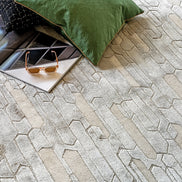 Handmade geometric rug with a textured monotone design and varying pile heights for contemporary luxury interiors.