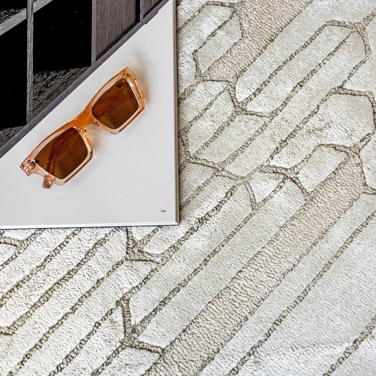Handmade geometric rug with a textured monotone design and varying pile heights for contemporary luxury interiors.