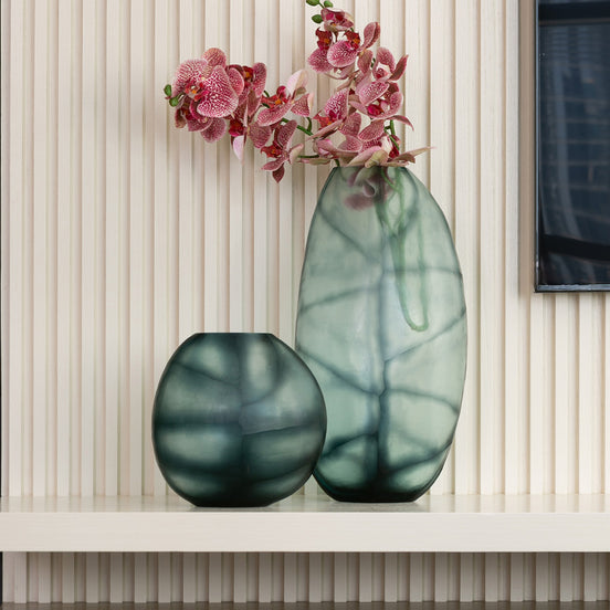 Hand-blown glass vase in ocean and indigo blue with a hand-finished design, available in two sizes for modern luxury interiors.