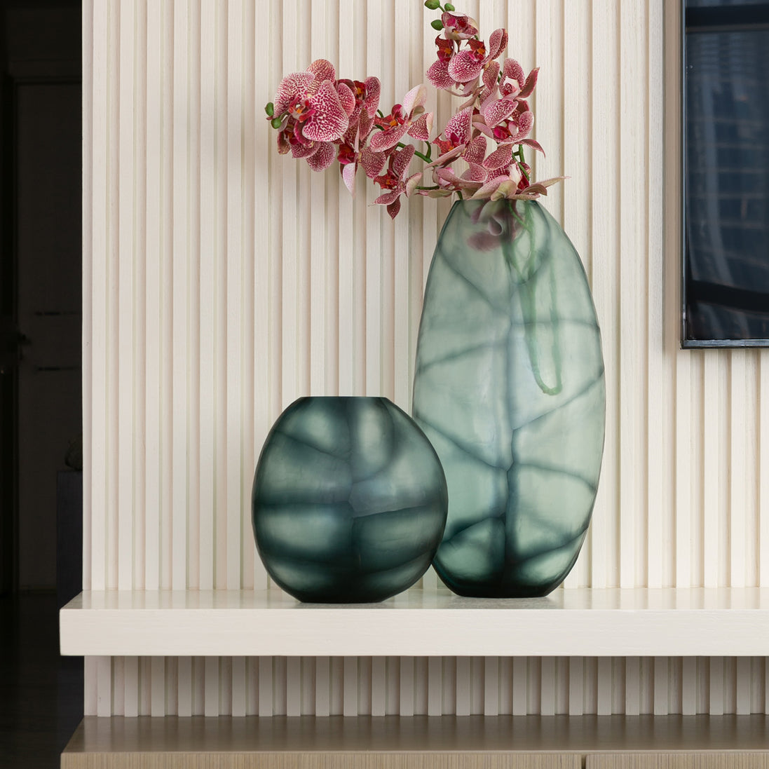 Hand-blown glass vase in ocean and indigo blue with a hand-finished design, available in two sizes for modern luxury interiors.