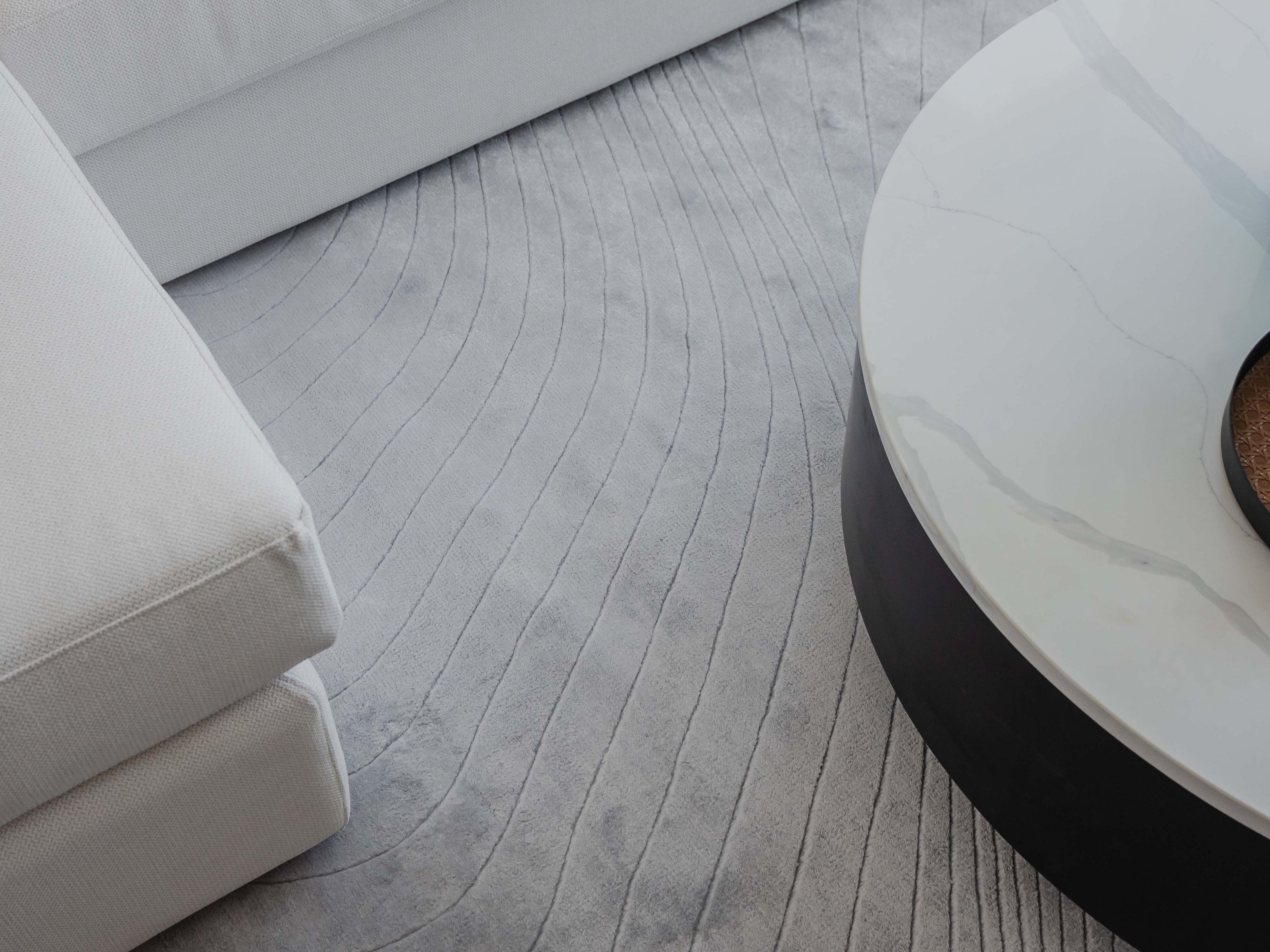 Handmade 100% Tencel rug with embossed wave carvings, subtle tonal texture, and a silky finish for modern luxury interiors.
