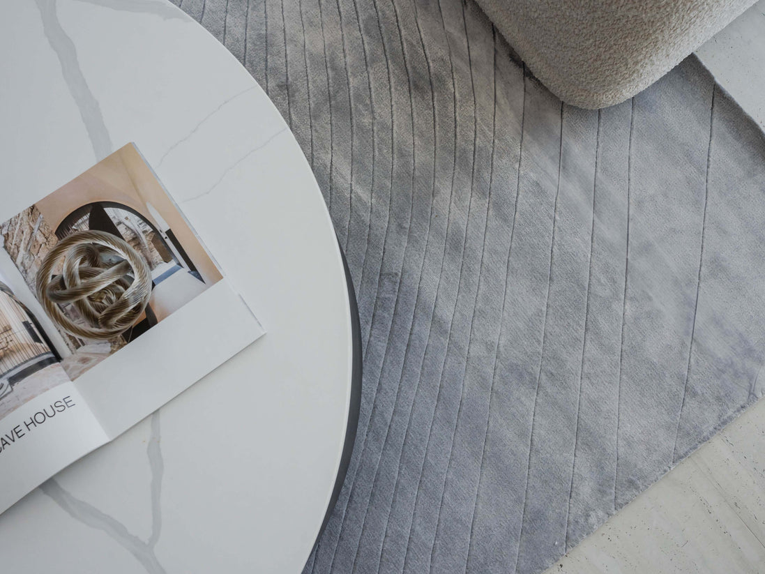 Handmade 100% Tencel rug with embossed wave carvings, subtle tonal texture, and a silky finish for modern luxury interiors.