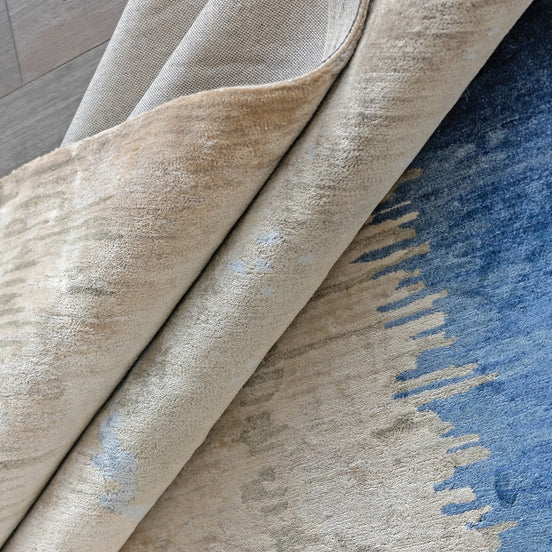 Handmade bamboo silk rug with layered blue tones inspired by the Greek island of Santorini and Mediterranean coastal landscapes.