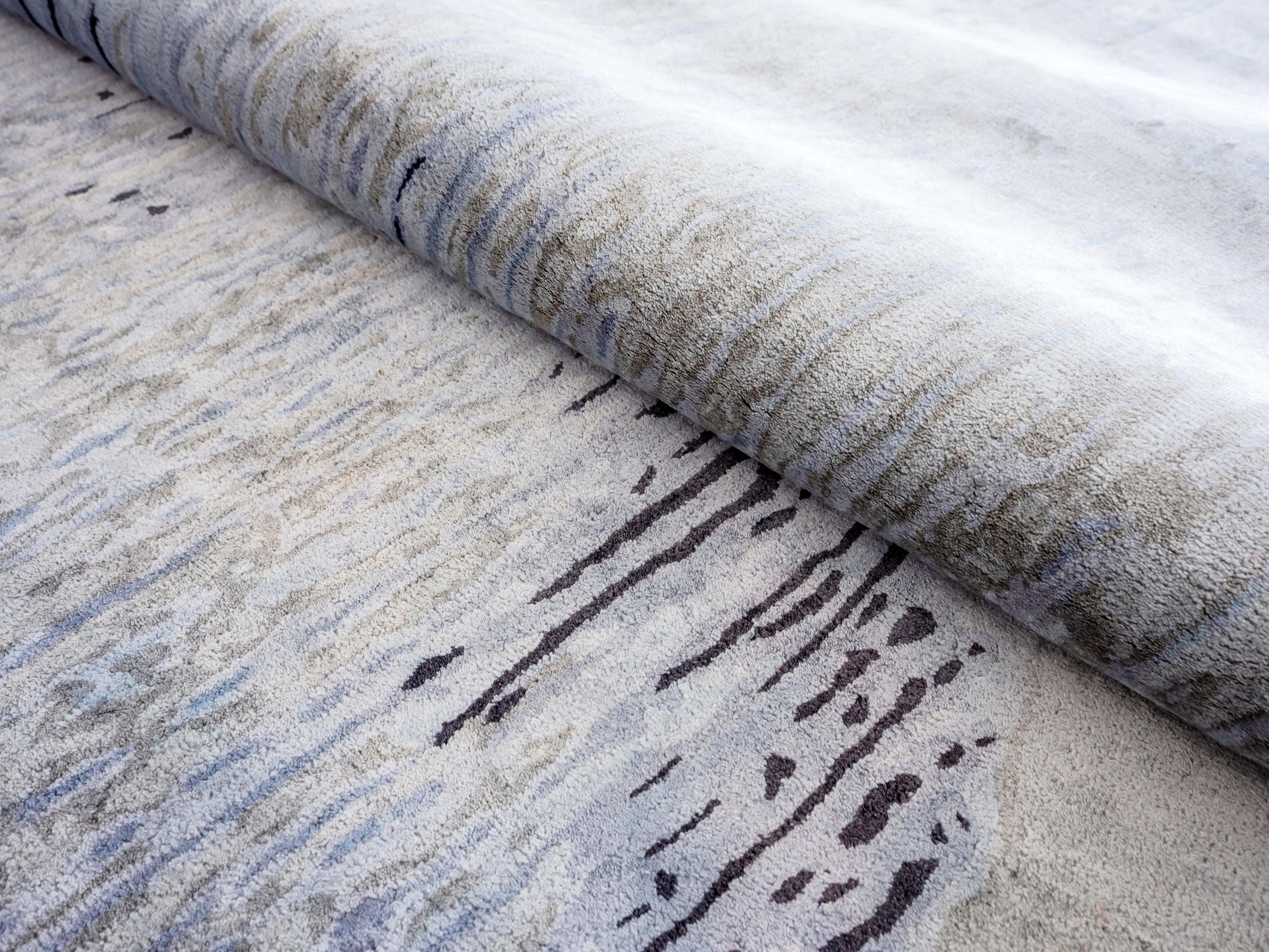 Handmade abstract rug inspired by blue stone and ocean waves with a flowing wave pattern, soft sheen, and velvety texture.