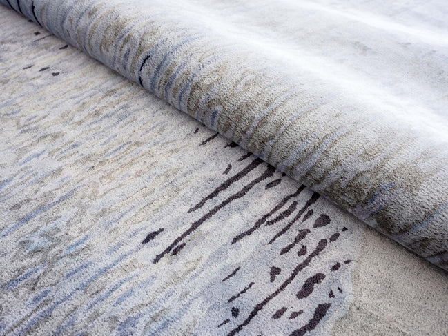 Handmade abstract rug inspired by blue stone and ocean waves with a flowing wave pattern, soft sheen, and velvety texture.