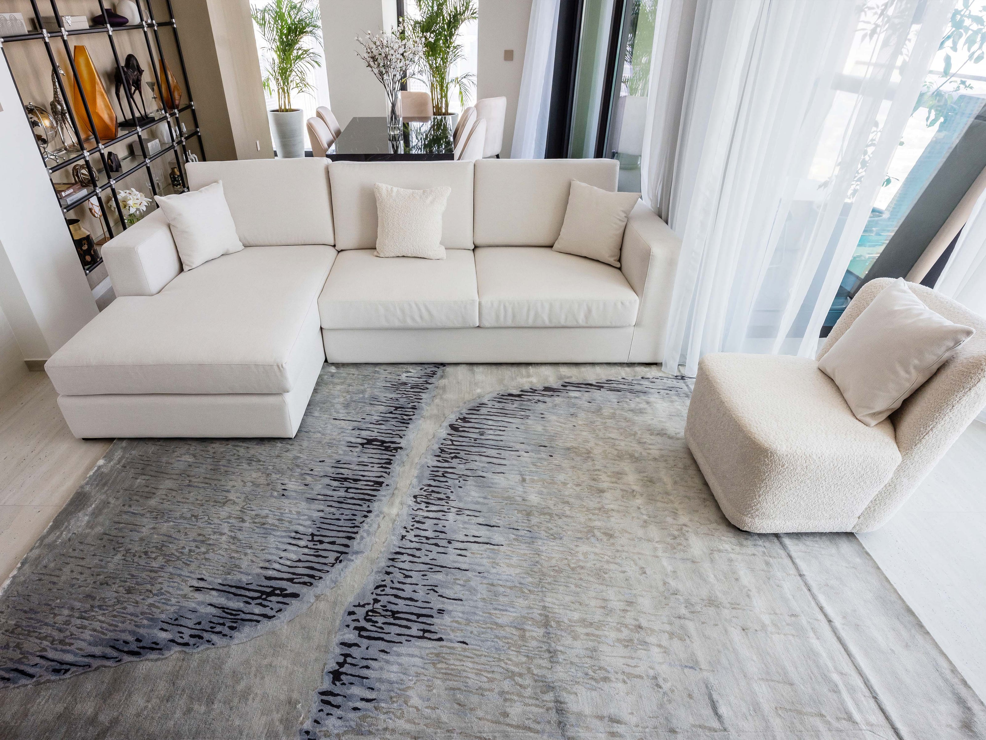 Handmade abstract rug inspired by blue stone and ocean waves with a flowing wave pattern, soft sheen, and velvety texture.