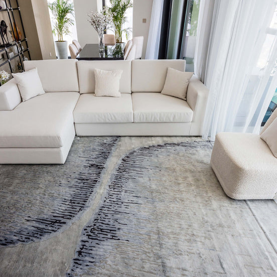 Handmade abstract rug inspired by blue stone and ocean waves with a flowing wave pattern, soft sheen, and velvety texture.