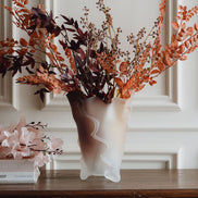 Frosted decorative glass vase with a red-to-yellow ombre finish and a sculptural floral-inspired silhouette for modern luxury interiors.