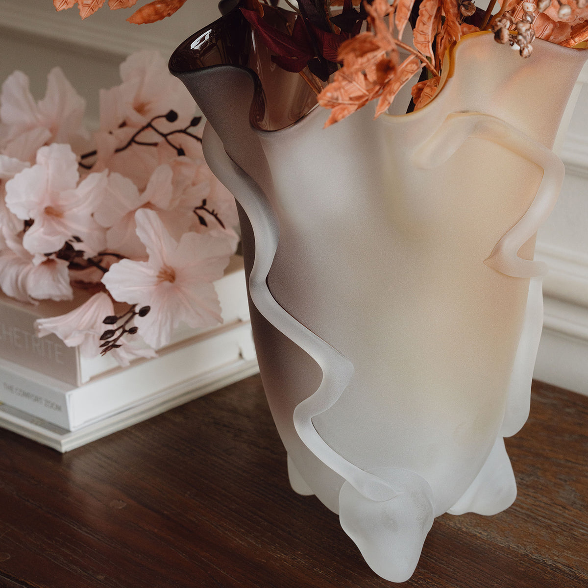 Frosted decorative glass vase with a red-to-yellow ombre finish and a sculptural floral-inspired silhouette for modern luxury interiors.