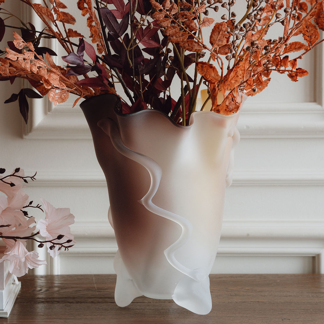 Frosted decorative glass vase with a red-to-yellow ombre finish and a sculptural floral-inspired silhouette for modern luxury interiors.