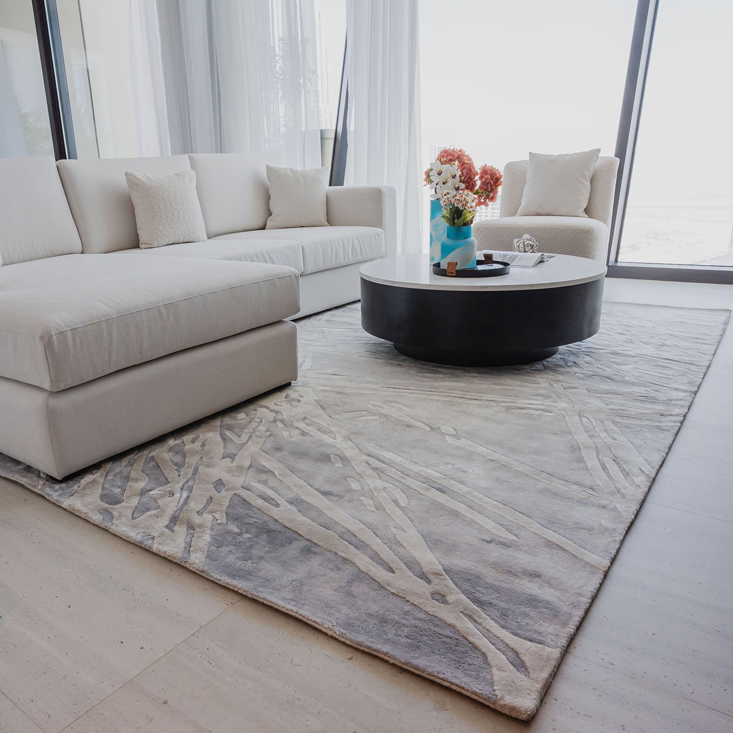Handmade silver-grey rug with raised ivory abstract patterns and a textured finish for contemporary luxury interiors.