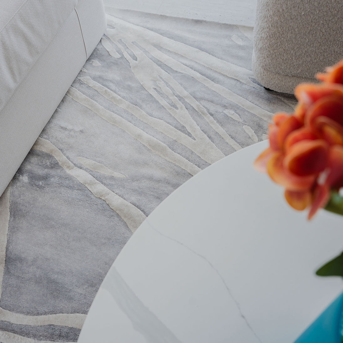 Handmade silver-grey rug with raised ivory abstract patterns and a textured finish for contemporary luxury interiors.