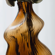 Hand-blown amber glass vase with an organic sculptural silhouette, perfect for modern and luxury interiors.