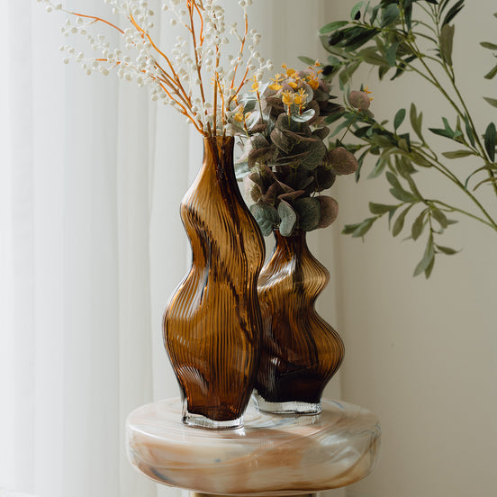 Hand-blown amber glass vase with an organic sculptural silhouette, perfect for modern and luxury interiors.