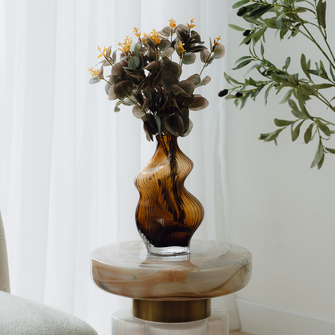 Hand-blown amber glass vase with an organic sculptural silhouette, perfect for modern and luxury interiors.