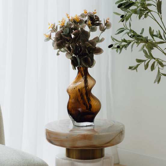 Hand-blown amber glass vase with an organic sculptural silhouette, perfect for modern and luxury interiors.