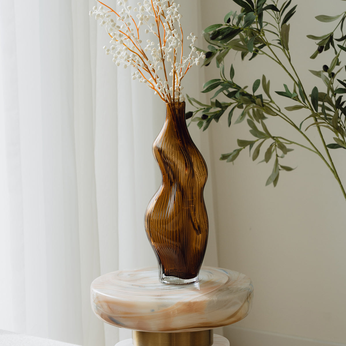 Hand-blown amber glass vase with an organic sculptural silhouette, perfect for modern and luxury interiors.