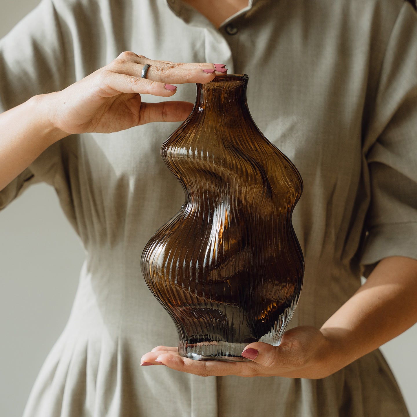 Hand-blown amber glass vase with an organic sculptural silhouette, perfect for modern and luxury interiors.