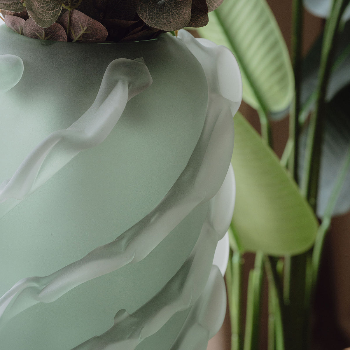 Frosted green decorative glass vase with a sculptural wave texture and organic silhouette for contemporary luxury interiors.